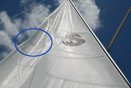 A tear in the sail due to the spreader