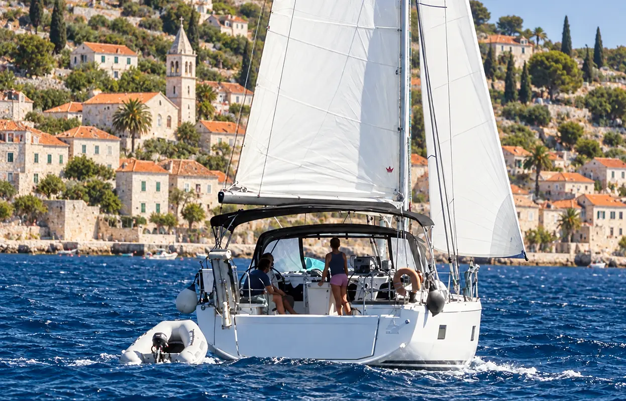 Sailboat approaching a town and harbor in Croatia